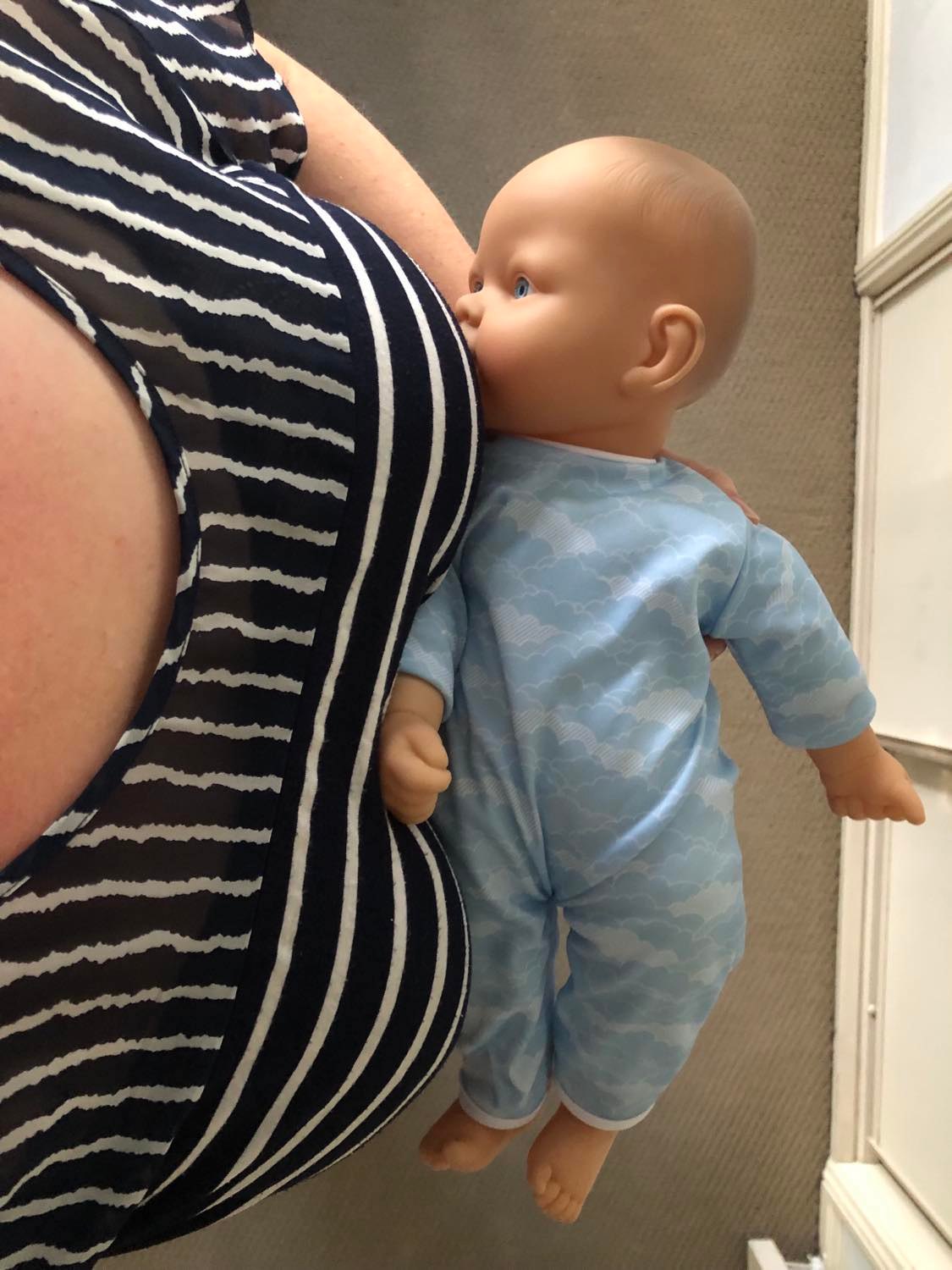 Baby doll demonstrating breastfeeding with poor positioning, tummy facing up to the roof - Arlie Hastings Lactation Consultant - Breastfeed support with home visits in Gold Coast, Tamborine, Logan and Redlands areas.