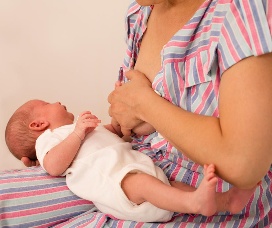 Mother holding her sore breast while baby lies on her lap. Nipple pain when breastfeeding - Arlie Hastings Lactation Consultant - breastfeeding support with home visits in the Gold Coast, Tamborine, Logan and Redlands areas.